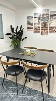 a black table with chairs and a plant on a wall at Funchal City Marina Apartment in Funchal