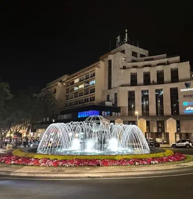 a water fountain in front of a building at night at Funchal City Marina Apartment in Funchal