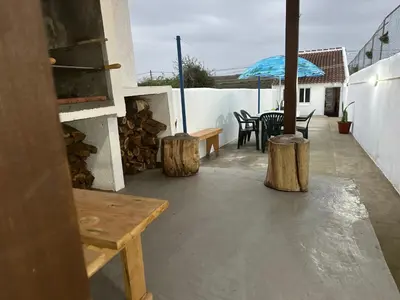 a patio with a table and chairs and an umbrella at Casinha Santa Maria in Vila do Porto