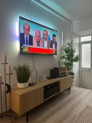 a living room with a flat screen tv on the wall at Casinha Santa Maria in Vila do Porto