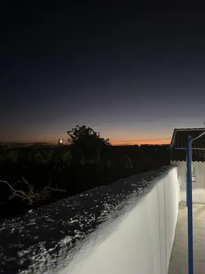 a concrete retaining wall with the sunset in the background at Casinha Santa Maria in Vila do Porto