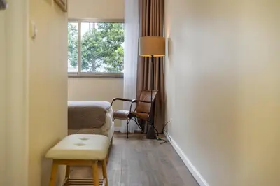 a room with a chair and a table and a window at SUPER Coral in Funchal