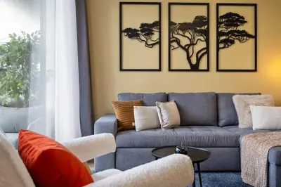 a living room with a blue couch with three pictures on the wall at SUPER Coral in Funchal