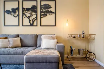 a living room with a blue couch and three pictures on the wall at SUPER Coral in Funchal