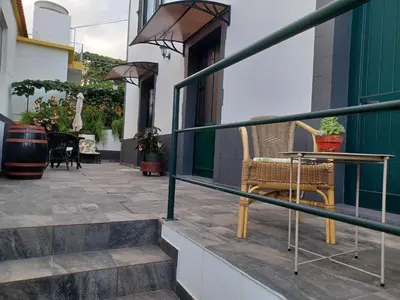 a patio with a table and chairs on a balcony at Sol & Maré in Calheta