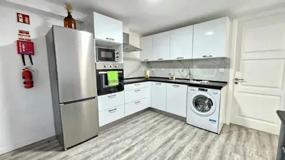 a kitchen with a refrigerator and a washing machine at Sol & Maré in Calheta