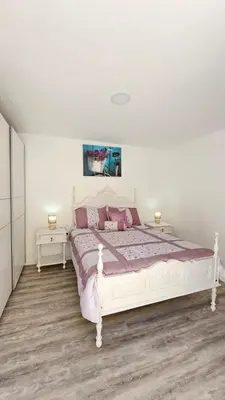 a white bed in a white room with two tables at Sol & Maré in Calheta