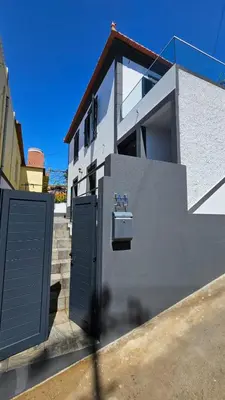 a building with two doors and a sink on the side at Sol & Maré in Calheta