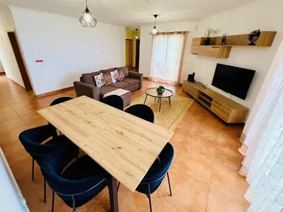 a living room with a table and a couch at Maria do Mar Apartment in Caniço