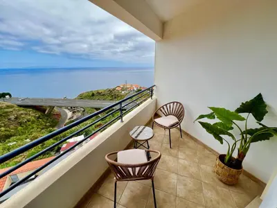a balcony with two chairs and a view of the ocean at Maria do Mar Apartment in Caniço