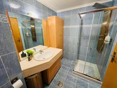 a bathroom with a sink and a shower at Maria do Mar Apartment in Caniço
