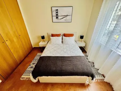 a bedroom with a bed and two night stands at Maria do Mar Apartment in Caniço