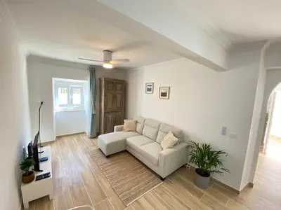 a living room with a couch and a tv at Casa do Sol in Sagres