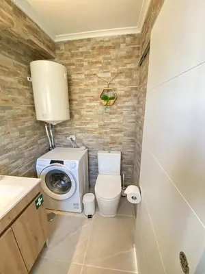 a bathroom with a washing machine and a toilet at Casa do Sol in Sagres