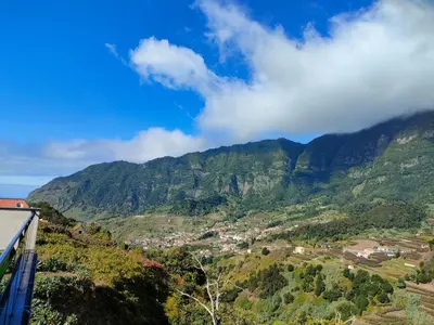 a balcony with chairs and a view of a mountain at Hillslope House in São Vicente