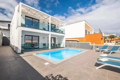 a villa with a swimming pool and a house at Luxury Seafront Escape I in Caniçal