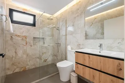 a bathroom with a toilet and a sink and a shower at Luxury Seafront Escape I in Caniçal