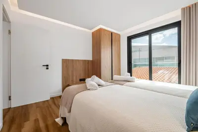 two beds in a bedroom with a large window at Luxury Seafront Escape I in Caniçal