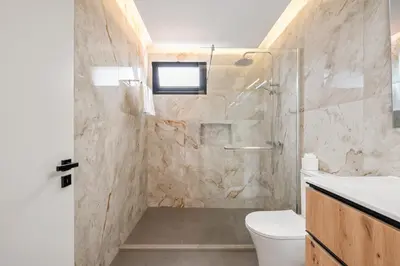 a bathroom with a shower and a toilet and a sink at Luxury Seafront Escape II in Caniçal