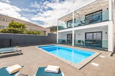 a swimming pool in the backyard of a house at Luxury Seafront Escape II in Caniçal