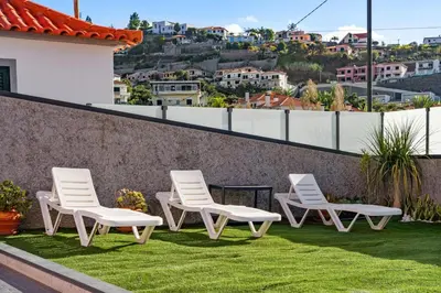 a group of chairs sitting on top of a roof at Mimi Holiday House - Free Parking in Funchal