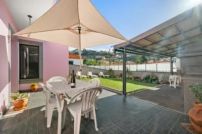 a white table with chairs and an umbrella on a patio at Mimi Holiday House - Free Parking in Funchal