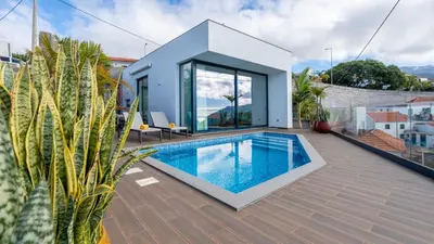 a house with a swimming pool on a roof at Moonlight Villa by LovelyStay in Estreito da Calheta