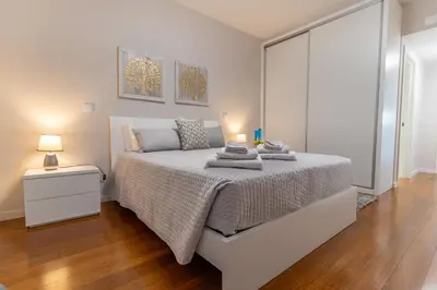 a white bedroom with a bed with towels on it at Alameda Formosa Varanda Zona Turística Funchal in Funchal