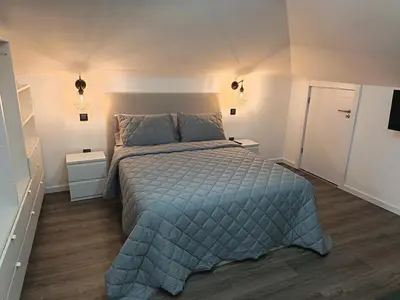 a bedroom with a bed with a blue comforter at Rose house in Ribeira Brava