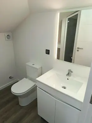 a white bathroom with a toilet and a sink at Rose house in Ribeira Brava