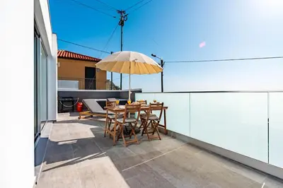 a wooden table with food and glasses of orange juice at Villa Bisa II, jacuzzi and sea view in Arco da Calheta