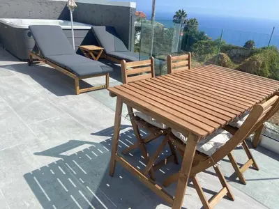 two lounge chairs sitting on top of a balcony at Villa Bisa II, jacuzzi and sea view in Arco da Calheta