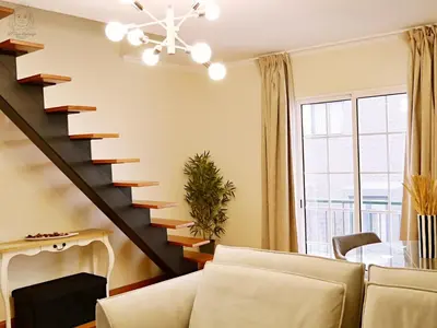 a living room with a staircase and a table at Dª Xica Holidays in Santa Cruz