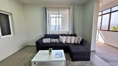 a living room with a couch and a table at Ninho's Sea View By Sam Houses in Ribeira Brava