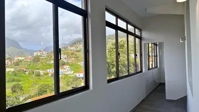 a room with windows with a view of a city at Ninho's Sea View By Sam Houses in Ribeira Brava