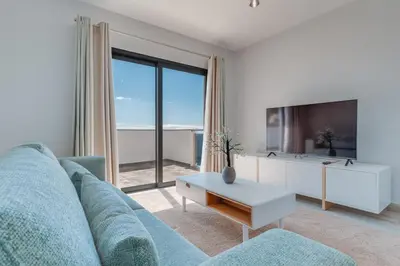 a living room with a blue couch and a tv at Vista Magnífica I by Holiday Rental Madeira in Campanário