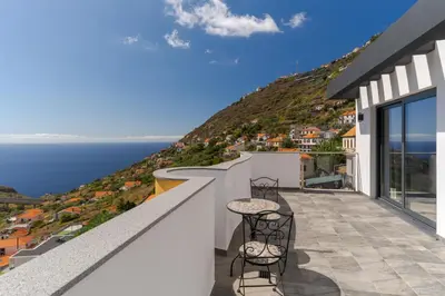 a balcony with two chairs and a view of the ocean at Vista Magnífica I by Holiday Rental Madeira in Campanário