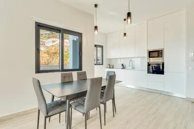 a kitchen and dining room with a table and chairs at Sonhos na Iha III by Holiday Rental Madeira in Campanário