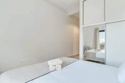 a white house on a hill next to the ocean at Alegria Residencial II by Holiday Rental Madeira in Campanário