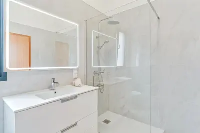 a white bathroom with a sink and a shower at Alegria Residencial II by Holiday Rental Madeira in Campanário