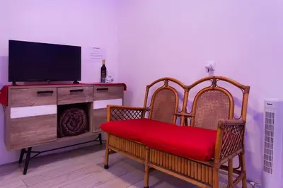 a living room with two chairs and a television on a dresser at Luci's House B in São Jorge