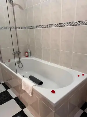 a white bath tub with a black remote control on it at Retiro encantador em Machico - 5 min Praia e Centro A in Machico