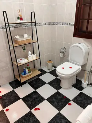 a bathroom with a toilet and a black and white checkered floor at Retiro encantador em Machico - 5 min Praia e Centro A in Machico