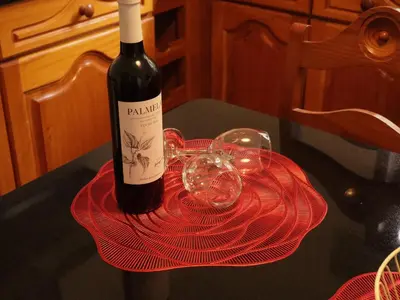 a bottle of wine sitting on a table with two glasses at Retiro encantador em Machico - 5 min Praia e Centro A in Machico