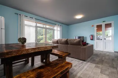 a living room with a table and a couch at Casa Vale Sereno by Rent-a-key in Cabo da Ribeira