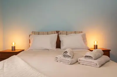 a bed with towels on it with two lit candles at Casa Vale Sereno by Rent-a-key in Cabo da Ribeira