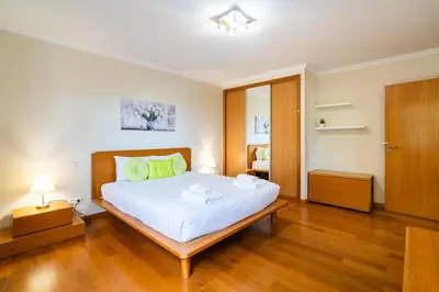 a bedroom with a large white bed with wooden floors at GuestReady - Relaxing escape with pool in Funchal