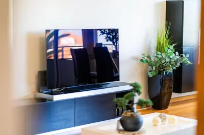 a living room with a tv on a entertainment center at GuestReady - Relaxing escape with pool in Funchal
