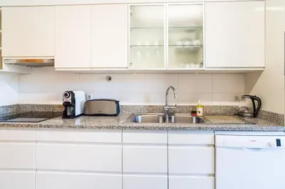 a kitchen with white cabinets and a sink at GuestReady - Relaxing escape with pool in Funchal