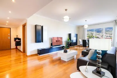 a living room with a couch and a tv at GuestReady - Relaxing escape with pool in Funchal